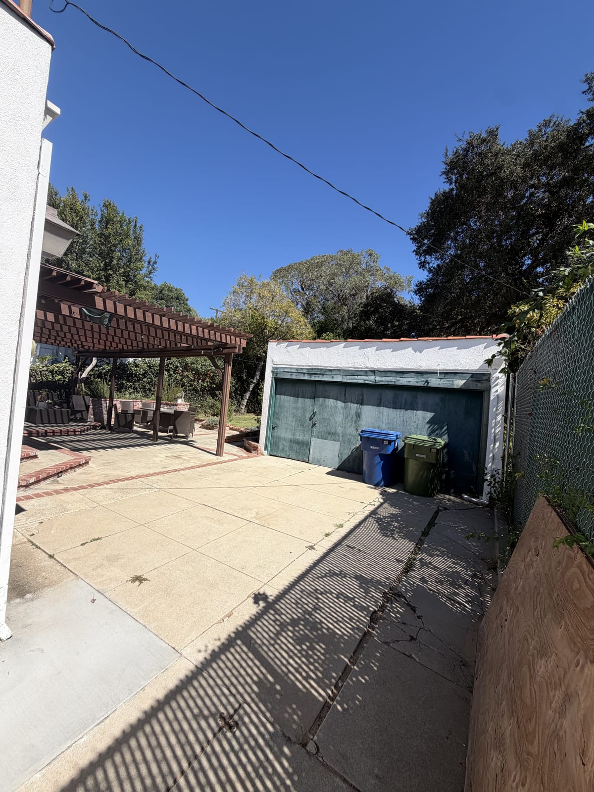 A detached garage with an old roll-up door and a cracked concrete approach